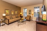 This single-story residence on Gettysburg Road in Canton, Michigan, offers a thoughtfully designed layout that balances comfort and functionality. The living area features neutral carpeting and warm terracotta accent walls, creating an inviting atmosphere complemented by natural light from multiple windows with blinds. Framed artwork and generous space for seating arrangements contribute to the room's welcoming character.

The dining area continues the warm color palette, with recessed track lighting overhead and room for a full dining set, making it well-suited for everyday meals and entertaining. Adjacent to the dining space, the kitchen is outfitted with medium-toned wood cabinetry, white appliances including a range, microwave, and refrigerator, and light tile flooring. A secondary area within the kitchen provides additional counter space and a built-in desk nook with access to an exterior door, bringing in natural light.

The bedroom is notably spacious, featuring plush carpeting, large windows with outdoor views of greenery, and a walk-in closet with built-in shelving for ample storage. A secondary closet and access to a bathroom with a wide vanity, white cabinetry, and tile flooring round out the private quarters. Throughout the home, neutral tones and consistent finishes create a cohesive, well-maintained ambiance.