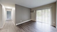 Located at 6252 Corbly St in Cincinnati, Ohio, this single-floor unit offers a well-organized layout with updated finishes throughout. The living area features durable wood-style flooring, neutral gray walls, and a sliding glass door framed by vertical blinds that allows natural light to filter in while providing views of the surrounding greenery. A wall-mounted air conditioning unit and baseboard heating ensure year-round comfort in the living space.

The galley-style kitchen is thoughtfully appointed with white shaker cabinetry, granite-patterned countertops, a stainless steel sink, and a suite of appliances including a refrigerator, electric range, and over-the-range microwave. Light wood-style flooring and bright overhead lighting give the kitchen a clean, modern feel.

The bedrooms offer plush carpeting, neutral tones, and individual windows with blinds that bring in natural light. Select bedrooms include wall-mounted air conditioning units and baseboard heaters, while one bedroom features access to a walk-in closet area. The bathroom is finished with white cabinetry, granite-style countertops, brushed nickel hardware, and a full tub-shower combination with a curved curtain rod. Wood-style flooring carries through the bathroom for a cohesive aesthetic across the unit.