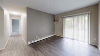Located at 6252 Corbly St in Cincinnati, Ohio, this single-floor unit offers a well-organized layout with updated finishes throughout. The living area features durable wood-style flooring, neutral gray walls, and a sliding glass door framed by vertical blinds that allows natural light to filter in while providing views of the surrounding greenery. A wall-mounted air conditioning unit and baseboard heating ensure year-round comfort in the living space.

The galley-style kitchen is thoughtfully appointed with white shaker cabinetry, granite-patterned countertops, a stainless steel sink, and a suite of appliances including a refrigerator, electric range, and over-the-range microwave. Light wood-style flooring and bright overhead lighting give the kitchen a clean, modern feel.

The bedrooms offer plush carpeting, neutral tones, and individual windows with blinds that bring in natural light. Select bedrooms include wall-mounted air conditioning units and baseboard heaters, while one bedroom features access to a walk-in closet area. The bathroom is finished with white cabinetry, granite-style countertops, brushed nickel hardware, and a full tub-shower combination with a curved curtain rod. Wood-style flooring carries through the bathroom for a cohesive aesthetic across the unit.