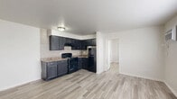 Located at 1930 S Goyer Rd in Kokomo, Indiana, this one-bedroom, one-bathroom unit offers a practical and well-organized layout across a single floor. Light wood-look flooring runs throughout the entire space, lending a clean and cohesive aesthetic to every room.

The open living area is bright and airy, featuring a large window fitted with blinds that allows ample natural light to fill the room. A wall-mounted air conditioning unit and baseboard heating ensure year-round comfort. The space flows directly into the kitchen, which is outfitted with dark, espresso-toned cabinetry, granite-style countertops, a tile backsplash, and black appliances including an electric range and refrigerator.

The bedroom is a comfortable, well-proportioned room with a sliding double-door closet and a window with blinds, offering both storage and natural light. Baseboard heating keeps the room warm, and clean white walls contribute to a fresh, neutral atmosphere.

The bathroom features a two-toned vanity with light blue-gray cabinetry, a white countertop, and a framed mirror. A separate water closet area houses the toilet and a full tub-shower combo with a white surround, keeping the space organized and functional.

Overall, the unit presents a clean, move-in-ready environment with consistent finishes throughout.