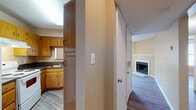 This single-floor residence offers a functional and comfortable layout across several well-defined living spaces. The living room serves as the heart of the home, featuring a classic corner fireplace with a white-trimmed mantel, warm neutral-toned walls, and wood-look laminate flooring that extends throughout the unit. Natural light filters in through multiple windows fitted with horizontal blinds, and a ceiling fan overhead ensures year-round comfort. The textured ceiling adds a traditional touch consistent across the common areas.

The kitchen is thoughtfully designed with an abundance of warm-toned wooden cabinetry both above and below the countertops, providing generous storage. Dark granite-style countertops contrast nicely with the lighter cabinetry, and the space is equipped with a white electric range, dishwasher, refrigerator, and a double-basin sink positioned beneath a window. The wood-look flooring continues seamlessly from the rest of the unit.

The bedrooms are bright and well-proportioned, each featuring neutral walls, wood-look flooring, ceiling fans with integrated lighting, and windows with blinds for natural light and privacy. The bathroom is clean and functional, with wood-look flooring and a bathtub/shower combination. Throughout the space, a cohesive neutral color palette and consistent flooring create a unified, move-in-ready atmosphere.