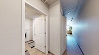 Located at 1225 Santa Fe Drive in Denver's vibrant arts district, this 1-bedroom, 1-bathroom unit offers a well-designed, modern living experience across a single floor. The open-concept living and kitchen area is bright and welcoming, with light wood-style flooring, exposed ductwork lending an industrial character, and a paneled ceiling that adds texture overhead. Two large windows flood the living space with natural light while framing sweeping city views of the Denver skyline and surrounding neighborhoods. The kitchen is efficiently appointed with slate-gray cabinetry, stainless steel appliances including a refrigerator, electric range, microwave, and dishwasher, complemented by a clean subway tile backsplash and a undermount sink. The bedroom is a quiet, cozy retreat, accessed through a decorative laser-cut partition screen, and includes a closet with built-in shelving. Exposed ductwork continues as a design element here, maintaining the unit's cohesive industrial-modern aesthetic. The bathroom features gray vanity cabinetry with a white countertop, light wood-style flooring, and clean, minimalist finishes throughout. A central hallway with a painted blue ceiling connects all areas, adding a subtle pop of personality to the overall design.