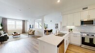 This well-designed two-bedroom, two-bathroom unit in San Diego, CA offers a thoughtfully laid-out single-floor plan that balances comfort and modern style. Light wood flooring flows throughout the space, lending warmth and continuity to every room.

The open-concept kitchen is a standout feature, showcasing crisp white shaker cabinetry, quartz countertops, a herringbone tile backsplash, stainless steel appliances, and a spacious peninsula with a double-basin sink — ideal for both cooking and entertaining. The kitchen opens seamlessly into the living room, which is brightened by large windows that invite natural light and offer views of the surrounding neighborhood. A sliding door provides additional light and access to the exterior.

The primary bedroom is generously sized, accommodating a queen or larger bed with ease, and features dual windows with blinds and drape treatments. It connects to a walk-in closet and a private en-suite bathroom with a white vanity and clean, modern finishes. The second bedroom is bright and cozy, also with natural light from a window. The second bathroom includes a full soaking tub with shower combination and recessed lighting.

A hallway connects the rooms efficiently, completing a functional and stylish layout well-suited for San Diego living.