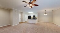Located at 1448 Grove Park Dr in Columbus, Georgia, this single-floor, one-bedroom, two-bathroom home offers a well-organized and functional layout across a generously sized floor plan. The kitchen and living area form an open, connected space anchored by a central island with a double sink, dark granite-style countertops, pendant lighting, and white cabinetry accented by a tile backsplash. Black appliances, including a refrigerator, range, and microwave, complement the clean, classic aesthetic. Crown molding and warm wood-look flooring carry throughout the kitchen and main areas, adding a polished finish. The living room is carpeted and trimmed with crown molding, providing a comfortable and defined space. The spacious primary bedroom features plush carpet, a ceiling fan with light fixture, and multiple windows that allow natural light to fill the room. The walk-in closet is equipped with wire shelving for ample storage. The primary bathroom includes a soaking tub and a tall built-in linen cabinet, while the second bathroom features a pedestal sink and wood-look flooring. Throughout the home, neutral tones, clean lines, and consistent finishes create a cohesive and inviting atmosphere.
