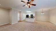 Located at 1448 Grove Park Dr in Columbus, Georgia, this single-floor, one-bedroom, two-bathroom home offers a well-organized and functional layout across a generously sized floor plan. The kitchen and living area form an open, connected space anchored by a central island with a double sink, dark granite-style countertops, pendant lighting, and white cabinetry accented by a tile backsplash. Black appliances, including a refrigerator, range, and microwave, complement the clean, classic aesthetic. Crown molding and warm wood-look flooring carry throughout the kitchen and main areas, adding a polished finish. The living room is carpeted and trimmed with crown molding, providing a comfortable and defined space. The spacious primary bedroom features plush carpet, a ceiling fan with light fixture, and multiple windows that allow natural light to fill the room. The walk-in closet is equipped with wire shelving for ample storage. The primary bathroom includes a soaking tub and a tall built-in linen cabinet, while the second bathroom features a pedestal sink and wood-look flooring. Throughout the home, neutral tones, clean lines, and consistent finishes create a cohesive and inviting atmosphere.