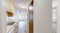 Located at 6276 12th St N in Oakdale, Minnesota, this two-bedroom, one-bathroom unit offers a practical and well-organized single-floor layout. The open-concept living, dining, and kitchen area serves as the heart of the home, where light wood-style laminate flooring flows seamlessly from the kitchen into the dining and living spaces. The kitchen features light wood cabinetry, white appliances including a range and refrigerator, and a galley-style corridor that leads into the main living area. A ceiling fan overhead and a large window bring natural light and airflow into the combined living and dining space, which is further supported by baseboard heating. A dedicated pantry provides additional storage convenience. Both bedrooms are carpeted in a neutral tan tone and each features a window with outdoor views, a ceiling-mounted light fixture, and sliding closet doors. The primary bedroom also benefits from access to additional closet space. The bathroom includes a full tub and shower combination with clean white surrounds and chrome fixtures. With four closets distributed throughout, storage is a notable strength of this unit. The textured ceilings and neutral color palette throughout create a clean, functional living environment suited for everyday comfort.