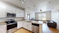 Located at 1706 N Ruddell St in Denton, TX, this 2-bedroom, 2-bathroom unit offers a well-designed single-floor layout that maximizes functionality and comfort. The open-concept kitchen flows seamlessly into the living area, creating a bright and connected living space. The kitchen is outfitted with crisp white cabinetry, granite countertops, stainless steel appliances including a refrigerator, range, microwave, and dishwasher, along with track lighting and pendant lights over the peninsula. Light hardwood-style flooring runs throughout the main living areas, complementing the neutral color palette.

The living room is bathed in natural light through large windows with outdoor views, and features a ceiling fan for added comfort. Both bedrooms are carpeted and include ceiling fans, as well as French doors that open to a private balcony, bringing in ample natural light and outdoor views. Each bedroom is paired with its own bathroom, which features granite-topped vanities and white cabinetry. Dedicated closet space is provided in each bedroom, with the primary bedroom featuring a set of double doors leading to a spacious closet. The unit offers a clean, modern aesthetic throughout, making it a practical and comfortable home in Denton.