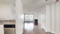 Located at 825 S Hobart Blvd in the heart of Los Angeles' Koreatown neighborhood, this one-bedroom, one-bathroom unit offers a well-designed layout across a single floor. Rich, dark hardwood flooring flows throughout, complementing the clean white walls and textured ceilings found in every room.

The open living area is a standout, anchored by a classic fireplace and a large sliding glass door framed by vertical blinds that invite natural light and provide outdoor views. Built-in wall shelving adds a functional and decorative touch to the living space. A ceiling fan in the adjoining hallway area enhances airflow and comfort throughout.

The kitchen is thoughtfully appointed with white shaker-style cabinetry, granite countertops, a stainless steel gas range, dishwasher, and a single-basin sink — offering both style and practicality in a compact, efficient layout.

The bedroom is a quiet retreat with a natural light window, two closets for ample storage, and the same warm hardwood flooring carried throughout the unit.

The bathroom features a granite-topped vanity with white cabinetry, built-in shelving, and a shower-tub combination enclosed by sliding glass doors, all finished with coordinating hardwood-style flooring for a cohesive look.