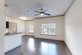 Located at 425 McCaleb Rd in Conroe, TX, this single-story 2-bedroom, 3-bathroom home offers a well-organized layout designed for comfortable everyday living. The open-concept kitchen and living area serves as the heart of the home, featuring rich dark cabinetry, granite countertops, stainless steel appliances including a range, microwave, dishwasher, and refrigerator, along with a central island with a sink. Dark hardwood-style flooring runs throughout the main living areas, complemented by abundant natural light from large windows with blinds and ceiling fans that enhance airflow and comfort. A dedicated laundry area with washer and dryer hookups is conveniently accessible from the kitchen. Both bedrooms are carpeted and include ceiling fans, closets, and windows with outdoor views, with the primary bedroom offering a private door to an outdoor balcony. The three bathrooms are finished with granite-topped dark vanities, tile flooring, and tiled tub/shower surrounds. Crown molding throughout the living areas adds an elevated architectural touch. Three closets provide ample storage across the home.