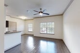 Located at 425 McCaleb Rd in Conroe, TX, this single-story 2-bedroom, 3-bathroom home offers a well-organized layout designed for comfortable everyday living. The open-concept kitchen and living area serves as the heart of the home, featuring rich dark cabinetry, granite countertops, stainless steel appliances including a range, microwave, dishwasher, and refrigerator, along with a central island with a sink. Dark hardwood-style flooring runs throughout the main living areas, complemented by abundant natural light from large windows with blinds and ceiling fans that enhance airflow and comfort. A dedicated laundry area with washer and dryer hookups is conveniently accessible from the kitchen. Both bedrooms are carpeted and include ceiling fans, closets, and windows with outdoor views, with the primary bedroom offering a private door to an outdoor balcony. The three bathrooms are finished with granite-topped dark vanities, tile flooring, and tiled tub/shower surrounds. Crown molding throughout the living areas adds an elevated architectural touch. Three closets provide ample storage across the home.