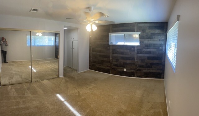 Dormitorio principal (panorámica) con pared revestida de paneles y puerta con espejo. - 1441 Prospect Ave