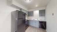 This two-bedroom, one-bathroom unit in Saginaw, Michigan offers a functional and thoughtfully updated single-floor layout. The kitchen is a standout feature, showcasing gray shaker-style cabinetry, granite-look countertops, wood-look luxury vinyl plank flooring, and a full suite of black appliances including a refrigerator, range, and dishwasher. Ample upper and lower cabinet storage makes this kitchen as practical as it is attractive.

The living area is generously sized, featuring plush neutral carpeting, baseboard heating, and multiple windows fitted with vertical blinds that allow for natural light. The open, airy feel of the space is enhanced by clean white walls and a straightforward layout that transitions easily between rooms.

Both bedrooms are comfortably proportioned with soft carpeting, neutral tones, and windows providing natural light. One bedroom features decorative wainscoting wall paneling, adding a subtle design touch.

The bathroom is clean and modern, with tile-surround tub and shower combination, wood-look flooring, a white vanity, and a window for ventilation and natural light. The overall ambiance of this unit is bright, neutral, and move-in ready, offering a comfortable living environment in a practical, well-organized floor plan.