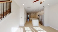 This well-designed two-story home in Charlotte, NC offers three bedrooms, three bathrooms, and a thoughtful layout spread across two floors. The main level greets you with an open-concept living, dining, and kitchen area filled with natural light from large windows and recessed lighting overhead. A ceiling fan anchors the living space, while the kitchen impresses with white shaker-style cabinetry, granite countertops, stainless steel appliances including a refrigerator, range, and microwave, and a central island with pendant lighting above. Light wood-tone flooring runs throughout the main level, lending a clean and modern aesthetic. A full bathroom on the main floor adds convenience. Upstairs, three bedrooms feature plush carpeting, ceiling fans, and ample natural light through double-pane windows with blinds. The primary bedroom is generously sized and connects to a private en-suite bathroom showcasing a dual-sink vanity with granite countertops and white cabinetry. Secondary bathrooms include a tub/shower combo with a white surround and granite vanity tops. Seven closets throughout the home, including wire-shelved bedroom closets, provide exceptional storage. A dedicated laundry area and a concrete walkway leading to the exterior complete this functional and inviting home.