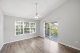 This 910-square-foot, single-story apartment offers a practical and well-appointed layout with 2 bedrooms, 2 bathrooms, and a combined kitchen and living area. The living room features wood-look plank flooring, neutral gray walls, and a sliding glass door that opens to a balcony, accompanied by an additional window that fills the space with natural light. The galley-style kitchen is equipped with white shaker cabinetry, granite-look countertops, a stainless steel double sink, black appliances including an electric range, dishwasher, and refrigerator, all set over matching wood-look flooring. The primary bedroom measures 170 square feet and features plush carpet flooring, a large window with blinds, and access to a closet. The second bedroom also features carpet flooring and a window providing natural light. Both bathrooms are finished consistently with wood-look flooring, white vanities with granite-look countertops, and full tub/shower combinations with white tile surrounds. A dedicated in-unit laundry room accommodates a full-size washer and dryer with overhead shelving. Two closets provide ample storage throughout the unit. The apartment maintains a cohesive, neutral color palette throughout.