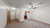 Located at 39 Cotterrew Drive in Columbus, Ohio, this single-floor unit offers a practical and comfortable layout suited for everyday living. The entryway, finished with wood-look flooring, transitions into a generously sized living area carpeted in neutral tones and topped with a textured ceiling and a ceiling fan with integrated lighting. A sliding glass door at the far end of the living space fills the room with natural light and provides views of lush greenery outside.

The kitchen is efficiently designed with warm wood cabinetry, stone-look countertops, a double-basin stainless steel sink, and white appliances including a refrigerator and dishwasher. A window above the sink brings in additional natural light, while ample upper and lower cabinet storage supports functional use of the space.

The unit includes multiple carpeted bedrooms, each featuring neutral walls, wood baseboard trim, and a textured ceiling. One bedroom is served by natural light through a window with blinds, while another offers a quieter, more enclosed feel.

The bathroom is finished with wood-look vinyl flooring, a vanity with a stone-look countertop and warm wood cabinetry, and a full tub-shower combination. Throughout the unit, consistent finishes including warm wood trim and neutral wall tones create a cohesive and welcoming atmosphere.