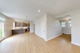 Located at 145 Cayuta St in Corning, NY, this well-appointed three-story home offers four bedrooms and four bathrooms across a generous and efficiently laid-out floor plan. The main living level features an open-concept kitchen and living area finished with light hardwood-style flooring and crisp white walls that create a bright, welcoming atmosphere. The kitchen is a standout, showcasing dark cabinetry with a subway tile backsplash, stainless steel appliances including a refrigerator and microwave, and a large center island with a built-in sink — ideal for both cooking and entertaining. Natural light filters in through multiple windows, enhancing the airy feel of the main floor. The bedrooms are thoughtfully distributed across the floors, with carpeted and hardwood-floored options providing versatility. The spacious primary bedroom offers a comfortable retreat. Additional rooms include two hallways for easy navigation between floors, a dedicated closet, and four full bathrooms finished in neutral tones. The attached garage features a wide door with windows, an automatic opener, and a concrete floor. The unfinished basement houses utility systems including a water softener and electrical panel. Outside, the home is clad in vinyl siding and sits on a grassy lot with a quiet neighborhood backdrop.