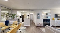 This single-story, 2-bedroom, 1-bathroom residence features a thoughtfully designed layout that maximizes functionality across its living spaces. The open-concept living and dining area serves as the heart of the home, with wood-style flooring, a cozy fireplace, and a large mirror wall in the dining space that enhances the sense of openness. A sliding glass door in the living room allows natural light to flow in while providing outdoor access. The galley-style kitchen is equipped with white shaker cabinetry, granite-style countertops, black appliances including a refrigerator, range, and dishwasher, a tile backsplash, and a stainless steel sink. The primary bedroom features plush carpeting, ample space, and direct access to a walk-in closet. The second bedroom, also carpeted, includes a window that invites natural light. The shared bathroom offers a wide vanity with quartz-style countertops, white cabinetry, a large mirror, and a shower-tub combination. A dedicated laundry room with washer/dryer hookups, an overhead shelf, and wood-style flooring adds everyday convenience. Two closets provide additional storage throughout the residence.