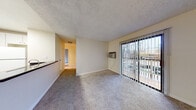 Located at 201 Ryan Dr in Pleasant Hill, CA, this single-floor residence offers a well-organized layout designed for comfortable everyday living. The living area features plush carpeting, a wall-mounted air conditioning unit, and a sliding glass door fitted with vertical blinds that opens to a private balcony, allowing natural light and outdoor views to filter into the space. A ceiling fan adds to the room's functionality. The kitchen is efficiently designed with white cabinetry, dark countertops, wood-look flooring, and white appliances including a range and refrigerator. A pass-through counter connects the kitchen to the living space, creating an open, communicative feel between the two areas. The bedrooms are generously proportioned, each featuring soft carpeting, neutral walls, and windows with vertical blinds that bring in natural light while offering views of the surrounding landscape. Baseboard heating is present in the bedrooms for added comfort. The bathroom area includes a wide vanity with dark countertops, white cabinetry, a large mirror with overhead lighting, and access to an additional bathroom space. Textured ceilings are consistent throughout, lending a cohesive character to the entire residence.