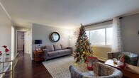 Located on the second floor at 754 State St in Eaton Rapids, Michigan, this unit offers a well-organized layout with comfortable living spaces and thoughtfully updated interiors throughout.

The living room serves as the central gathering area, featuring rich dark hardwood flooring, a textured ceiling, and a wall-mounted A/C unit. A large window allows natural light to fill the space, which comfortably accommodates a full sofa, area rug, and side furnishings.

The kitchen is outfitted with white cabinetry, dark granite-style countertops, a penny tile backsplash, and light wood-look flooring. Appliances include a refrigerator, and ample counter space supports everyday use. Adjacent to the kitchen is a dedicated dining area with room for a four-person table, accented by a decorative circular wall shelf.

Two bedrooms provide comfortable accommodations. The primary bedroom features crown molding, a ceiling fan, a window with views of the surrounding area, and dark hardwood flooring. The second bedroom mirrors a similarly cozy layout with its own window and hardwood floors.

The bathroom is cleanly finished with large marble-style wall tiles surrounding the tub and shower, wood-look flooring, and a vanity with light countertops, creating a bright, fresh aesthetic throughout.