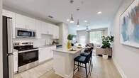 Located at 350 Bay Laurel Dr in St. Augustine, FL, this well-appointed 2-bedroom, 2-bathroom residence offers a thoughtfully designed single-level layout. The open-concept kitchen and living area serves as the heart of the home, where crisp white shaker cabinetry, granite countertops, and a full suite of stainless steel appliances — including a refrigerator, range, and microwave — create a sleek, functional space. A central kitchen island with seating provides an ideal spot for casual dining or entertaining. Light wood-style flooring flows seamlessly throughout the main living areas, enhancing the bright, airy atmosphere. The living room is bathed in natural light through large windows and a glass door, complemented by a ceiling fan and ample space for relaxing. Both bedrooms feature plush carpeting and direct access to a dedicated closet, with the primary bedroom offering an ensuite bath. Each bathroom is finished with wood-look tile flooring, granite vanity tops, and a tiled tub-shower combination. The neutral, warm color palette throughout the residence creates a cohesive and inviting ambiance, making this St. Augustine home a comfortable and stylish retreat.
