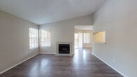 This single-floor residence offers a thoughtfully designed layout with distinct living, dining, and kitchen areas that flow cohesively throughout the space. The living room serves as the central gathering area, anchored by a tile-surround fireplace and finished with dark hardwood-style flooring that extends throughout the main living areas. Multiple windows flood the space with natural light, while a sliding glass door opens directly onto a private balcony, bringing in outdoor views of surrounding greenery. A pass-through opening connects the living area to the adjacent dining space and kitchen, enhancing the open feel.

The kitchen is well-equipped with white cabinetry, granite-style countertops, stainless steel appliances including a range, microwave, dishwasher, and refrigerator, and durable light wood flooring. The bedrooms feature plush carpeting, ceiling fans, and dedicated walk-in closets, providing ample storage. Each room benefits from natural light through well-positioned windows.

The bathrooms are finished with white vanity cabinetry, granite-style countertops, large mirrors, and wood-style flooring. One bathroom includes a walk-in shower, while another features a tub-shower combination. Textured ceilings and neutral wall tones carry throughout, giving the space a cohesive and functional character.