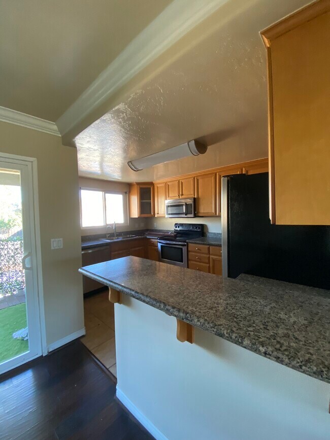 Cocina con encimeras de granito y barra. - 4849 Williamsburg Ln