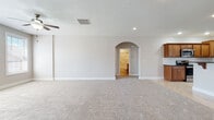 Located at 14 Saint Ivans Circle in Bloomington, Illinois, this single-story home offers a thoughtfully designed layout with a blend of comfort and practicality. The spacious main living area is finished with plush neutral carpeting and features a ceiling fan, recessed lighting, and an elegant arched doorway that adds architectural character while connecting to adjacent spaces. Clean white walls and crisp baseboards throughout contribute to a bright, cohesive aesthetic.

The kitchen is a functional highlight, showcasing rich medium-toned wood cabinetry, dark granite countertops, and a classic white subway tile backsplash. Stainless steel appliances, including a side-by-side refrigerator and range, complement the tile flooring laid in a diagonal pattern. A peninsula provides additional counter space, and a window allows natural light to fill the room. The kitchen opens conveniently to the dedicated laundry area, which includes a full-size washer and dryer, tile flooring, and a double sliding closet for additional storage.

The primary bedroom is generously sized, featuring a trio of windows that bring in ample natural light, soft carpeting, and a ceiling fan. Its en-suite bathroom includes a tiled soaking tub set beneath a bright window, a wood vanity, and tile flooring. Additional bedrooms offer carpeting and sliding closet doors, while a secondary full bathroom includes a tub-shower combination and a wood vanity.