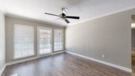 Located at 13110 Kuykendahl Rd in Houston, TX, this single-story unit offers a well-designed layout with a variety of functional and comfortable spaces throughout. The living area makes a strong impression with rich hardwood-style flooring, crown molding, a ceiling fan with light fixture, and a classic fireplace framed in white tile — an ideal focal point for the room. French doors with slatted blinds invite natural light and provide access to the outdoors, enhancing the open feel of the space. The galley-style kitchen is efficiently arranged with dark espresso cabinetry, marble-look countertops, stainless steel appliances including a refrigerator, range, microwave, and dishwasher, and a deep sink. A peninsula counter connects the kitchen to the adjoining area, offering additional prep or casual dining space. The bedrooms feature plush neutral carpet, ceiling fans, and windows with blinds that allow for ample natural light while maintaining privacy. Each room provides a calm, comfortable atmosphere. The bathroom is clean and functional, featuring a tub-shower combination, dark vanity cabinetry, and hardwood-style flooring. Throughout the unit, neutral gray walls and white trim create a cohesive, modern aesthetic.