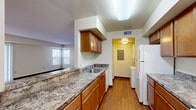 Located at 46558 Valley Ct in Lexington Park, MD, this well-laid-out single-floor residence offers two bedrooms, two bathrooms, and a thoughtfully designed floor plan. Rich wood-style flooring flows consistently throughout the home, adding warmth and cohesion to each room.

The galley-style kitchen is a functional highlight, featuring warm wood cabinetry, stone-patterned countertops, a double sink, and white appliances including a range and refrigerator. The kitchen opens toward a dedicated utility room, which conveniently houses an in-unit washer and dryer. A pass-through design connects the kitchen to the living area, enhancing the open feel.

The living room is bright and welcoming, with a ceiling fan, large sliding glass door with vertical blinds that invite natural light and outdoor views, and ample space for comfortable living.

The spacious primary bedroom features natural light through a large window with wooded views, while the second bedroom is equally well-proportioned. Both closets provide generous storage, with one featuring wire shelving for added organization. The bathrooms are clean and functional, each offering a tiled tub-and-shower combination. A central hallway connects all areas efficiently, completing this comfortable and practical home.