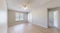 Located at 4635 Cason Cove Dr in Orlando, FL, this 2-bedroom, 2-bathroom home offers a practical and comfortable single-floor layout. The living room is a bright, open space featuring light wood-style flooring, a ceiling fan, and large windows that invite natural light. Elegant French doors connect the living area to the private balcony, extending the functional living space outdoors. The kitchen is positioned adjacent to the living room and features warm wood cabinetry, light countertops, black appliances including a refrigerator and range, a stainless steel dishwasher, and a skylight that adds additional brightness. Both bedrooms are carpeted and well-sized, with the primary bedroom offering notable square footage, a ceiling fan, and direct access to natural light through a window with blinds. The five closets throughout the home — including a generously sized walk-in — provide exceptional storage. Each bathroom includes a single vanity with a large mirror and a tub/shower combination with light wood-style flooring. A dedicated in-unit laundry room with stacked washer and dryer and additional wire shelving adds everyday convenience. Neutral tones and textured ceilings carry throughout, giving the home a clean, cohesive feel.