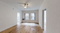 Located at 520 S Mariposa Ave in the Koreatown neighborhood of Los Angeles, this single-floor unit offers a thoughtfully updated interior with a cohesive, contemporary aesthetic throughout. Light wood laminate flooring runs continuously across all rooms, creating a warm and unified feel from entry to bedroom.

The main living area is open and airy, with crisp white walls, a ceiling fan with integrated lighting, and multiple windows that allow natural light to fill the space. A wall-mounted gas heater provides supplemental heating. The layout connects fluidly to the bedroom, which mirrors the living area's clean design and also features a ceiling fan and generous wall space.

The kitchen is well-appointed with gray shaker-style cabinetry, white quartz countertops, a stainless steel gas range, an under-cabinet range hood, and a single-basin stainless steel sink. The cabinetry offers ample upper and lower storage, making the kitchen both functional and visually polished.

The bathroom maintains the home's bright, minimalist character with all-white finishes, a subway tile soaking tub with an overhead shower, a single-sink vanity with cabinet storage, and a window for natural ventilation. The wood flooring extends into this space as well, reinforcing the unit's consistent design language throughout.