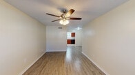 This two-story home offers a well-organized layout across two levels, providing 2 bedrooms and 1.5 bathrooms. The main living area features light-toned wood-look flooring and a ceiling fan with integrated lighting, creating a bright and comfortable space. The open sightline connects the living area directly to the kitchen, enhancing the sense of flow throughout the main floor.

The kitchen is equipped with rich, dark cherry-toned cabinetry offering ample storage, granite-look countertops, a stainless steel sink, and a full suite of black appliances including a refrigerator, electric range with overhead ventilation, and dishwasher. Tile flooring and a window with blinds complete the space.

The bedrooms are located on the upper level, each featuring warm-toned hardwood-style flooring, ceiling fans, and windows with blinds that allow natural light. One bedroom includes a closet with a dedicated door. The full bathroom serves the upper level and features rich wood vanity cabinetry, granite-look countertops, a large framed mirror, a soaking tub, and wood-look flooring. A half bathroom is conveniently located on the main level. Textured ceilings are consistent throughout the home.