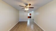 This two-story home offers a well-organized layout across two levels, providing 2 bedrooms and 1.5 bathrooms. The main living area features light-toned wood-look flooring and a ceiling fan with integrated lighting, creating a bright and comfortable space. The open sightline connects the living area directly to the kitchen, enhancing the sense of flow throughout the main floor.

The kitchen is equipped with rich, dark cherry-toned cabinetry offering ample storage, granite-look countertops, a stainless steel sink, and a full suite of black appliances including a refrigerator, electric range with overhead ventilation, and dishwasher. Tile flooring and a window with blinds complete the space.

The bedrooms are located on the upper level, each featuring warm-toned hardwood-style flooring, ceiling fans, and windows with blinds that allow natural light. One bedroom includes a closet with a dedicated door. The full bathroom serves the upper level and features rich wood vanity cabinetry, granite-look countertops, a large framed mirror, a soaking tub, and wood-look flooring. A half bathroom is conveniently located on the main level. Textured ceilings are consistent throughout the home.
