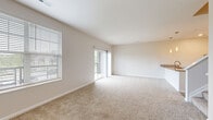 Located at 277 Bend Blvd. in Westerville, Ohio, this two-bedroom, two-bathroom two-story home offers a well-organized layout spread across two floors. The main level hosts a combined kitchen and living room, designed as an open-concept space filled with natural light from large windows and a sliding glass door that leads to a private patio with outdoor views. The kitchen is outfitted with white shaker-style cabinetry, granite countertops, and stainless steel appliances, including a range and over-the-range microwave. Light wood-style flooring runs through the kitchen and entry areas, while plush carpet covers the living area. A full bathroom on the main level features a white vanity with granite countertop and tile-style flooring. Upstairs, two carpeted bedrooms offer comfortable retreats, each with windows that invite ample natural light. The primary bedroom connects directly to a full bathroom complete with a tub-shower combination, white cabinetry, and matching granite countertops. A dedicated laundry area and five closets throughout the home provide generous storage. Clean neutral tones and consistent finishes give the space a bright, move-in-ready feel throughout.