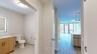 Located at 345 E Wacker Drive in the heart of Chicago, this one-bedroom, one-bathroom residence offers a thoughtfully designed open-concept layout with modern finishes throughout. Light wood-tone flooring flows seamlessly across the living, dining, and kitchen areas, creating a cohesive and airy aesthetic.

The combined kitchen and living room serves as the centerpiece of the space. The kitchen is outfitted with flat-front cabinetry in a warm wood grain finish, a full suite of stainless steel appliances including a gas range, built-in microwave, dishwasher, and refrigerator, complemented by a white subway tile backsplash and a central island with a light quartz countertop and pendant lighting above. Floor-to-ceiling sliding glass doors in the living area frame sweeping views of the Chicago skyline, filling the space with abundant natural light and providing access to a private balcony.

The generously sized primary bedroom offers a calm, neutral palette with the same light hardwood flooring and large windows that invite natural light. Two closets provide practical storage. The bathroom features clean tile flooring, neutral walls, and gold-tone hardware accents. A dedicated entrance area completes the layout, adding a functional transition zone. The overall ambiance is clean, contemporary, and bright.
