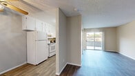 Located at 439 West El Norte Parkway in Escondido, California, this efficiently designed unit offers a well-organized single-floor layout comprising a living room, kitchen, and full bathroom. Durable wood-look flooring runs throughout, complemented by neutral-toned walls and textured ceilings that create a clean, cohesive aesthetic.

The kitchen is thoughtfully arranged with white shaker-style cabinetry extending to the upper walls, providing ample storage. Dark countertops offer a pleasing contrast, and the space is equipped with a full suite of white appliances including a refrigerator, electric range, built-in microwave, and a double-basin sink beneath under-cabinet lighting.

The living area is open and airy, bathed in natural light through a large sliding glass door that opens onto a private balcony with views of the surrounding neighborhood. A closet provides additional storage within the living space. The room's straightforward layout offers flexible arrangement options.

The bathroom features a walk-in shower with a curved curtain rod and grab bars for added accessibility, a vanity with gray countertop and vessel-style sink, and wood-look flooring consistent with the rest of the unit. A window allows for natural light and ventilation.

Overall, the unit presents a practical and well-maintained living environment suited for those seeking a comfortable, move-in-ready space in Escondido.