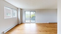 Located at 215 St Bellevue in Sherbrooke, Quebec, this 2-bedroom, 1-bathroom unit offers a clean and functional layout across a single floor. Warm-toned hardwood flooring flows consistently throughout the main living areas and bedrooms, lending a cohesive and inviting feel to the space. The living room is generously sized, featuring large sliding glass doors that open onto a private balcony with open views of the surrounding landscape and hills — a notable highlight of the unit. An additional window further brightens the room with natural light. The kitchen is equipped with white cabinetry, ample counter space, a dishwasher, and a stainless steel sink, offering a practical and tidy workspace. Both bedrooms are well-proportioned with neutral grey walls, textured ceilings, and large sliding closets providing excellent storage. The primary bedroom benefits from a window with an outdoor view. The bathroom is thoughtfully designed to accommodate in-unit washer and dryer hookups alongside the vanity and tiled shower area, maximizing functionality. A hallway and dedicated closet round out the layout, ensuring efficient use of the available space throughout this well-maintained Sherbrooke residence.