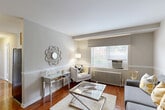 Located at 2203 Guilford Rd in Hyattsville, MD, this one-bedroom, one-bathroom residence offers a well-designed single-floor layout that maximizes every inch of its compact footprint. The inviting living room serves as the heart of the home, showcasing rich hardwood floors, neutral-toned walls with classic chair rail molding, and a large window that draws in natural light while offering views of the surrounding greenery. A classic cast-iron radiator adds a charming architectural detail. The space flows naturally into a dedicated dining area, making it ideal for everyday living and entertaining. The kitchen is equipped with light wood cabinetry, granite-style countertops, a gas range, and a window above the sink that keeps the space bright and airy. Tile flooring completes the practical yet pleasant cooking area. The bedroom is a calm and comfortable retreat, featuring hardwood floors, a window with exterior views, and access to multiple closets for generous storage. The full bathroom is finished with neutral tile work, a tub-shower combination, a light wood vanity, and tile flooring, offering a clean and functional design. A hallway connects the rooms efficiently, rounding out a thoughtfully organized and move-in ready home.