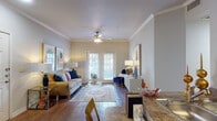 Located at 6674 Prue Rd in San Antonio, Texas, this single-floor residence offers a thoughtfully designed layout with a warm and welcoming ambiance throughout. The open-concept living area is a standout feature, showcasing rich hardwood flooring, elegant crown molding, and a ceiling fan that adds both style and function. French doors flood the space with natural light and provide access to the outdoors, creating a seamless indoor-outdoor connection. The living room offers generous space for comfortable seating and entertaining, with neutral walls that complement a variety of décor styles. Adjacent to the living area, the galley-style kitchen is well-appointed with warm wood cabinetry, granite-style countertops, and black appliances, offering ample storage and prep space. The residence includes two bedrooms, each carpeted for comfort and equipped with ceiling fans and windows that invite natural light. The primary bedroom connects to a bathroom featuring a granite-topped vanity with rich wood cabinetry, hardwood flooring, and a walk-in closet providing excellent storage. The overall design balances classic architectural details with practical living spaces, making this San Antonio residence both functional and inviting.