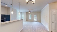 Located at 8500 Franciscan Woods Dr in Columbus, GA, this single-floor residence offers a thoughtfully arranged layout comprising one bedroom, one bathroom, a kitchen, and a dedicated closet. The open living and dining area is bright and welcoming, featuring neutral-toned carpet, crown molding, and multiple windows fitted with blinds that allow natural light to filter through. A ceiling fan with a light fixture adds both comfort and functionality to the space, while a glass-paneled exterior door provides access to an outdoor area with pleasant views of the surrounding greenery. The kitchen is efficiently designed with dark cabinetry, granite-look countertops, tile flooring, and black appliances including a refrigerator, electric range, and built-in microwave. The bedroom is a comfortable retreat with plush carpeting, a ceiling fan, and a window offering natural light and outdoor views. A spacious walk-in closet off the bedroom features wire shelving on multiple walls, maximizing storage capacity. The bathroom is clean and functional, showcasing dark wood cabinetry, a single-sink vanity with a large mirror, tile flooring, and a well-lit vanity fixture. Throughout the residence, a consistent neutral color palette creates a cohesive and inviting atmosphere.