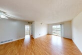 Located at 2224 Village Green Pkwy in Chesterfield, MO, this one-bedroom, one-bathroom unit offers a well-organized single-floor layout designed for comfortable everyday living. The living room serves as the heart of the space, featuring warm hardwood-style flooring, crisp white walls, and a textured ceiling. A sliding glass door floods the room with natural light and opens to a private balcony overlooking pleasant outdoor scenery, creating a bright and airy atmosphere throughout. The galley-style kitchen is efficiently designed with dark cabinetry, light countertops, a white tile backsplash, and black appliances including a refrigerator and range. A window above the sink provides additional natural light, making the kitchen feel open despite its compact footprint. The bedroom is a comfortable retreat, finished with plush carpeting and multiple closet doors offering generous storage. A window with blinds brings in natural light while maintaining privacy. The bathroom features a full tub-shower combination with white tile surround, complemented by earthy tile flooring and wall-mounted cabinetry for added storage. Overall, the space presents a clean, functional design with consistent finishes throughout, making it a practical and inviting home in the Village Green community.