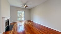 Located at 3400 Stratford Rd NE in Atlanta's prestigious Buckhead neighborhood, this single-floor residence offers a thoughtfully designed layout across a comfortable footprint. Rich, polished hardwood floors flow throughout the main living areas, lending warmth and visual continuity to the space.

The open-concept kitchen and living room serves as the heart of the home. The kitchen is outfitted with dark espresso cabinetry, a white quartz-topped center island, a tile backsplash, and a full suite of stainless steel appliances including a refrigerator, range, microwave, and dishwasher. Pendant lighting above the island adds a modern touch. The living area features a classic fireplace with a white mantle and black surround, as well as a ceiling fan and a window that brings in natural light with views of surrounding greenery.

The bathroom is clean and functional, featuring light tile flooring, a white vanity with under-mount sink and ample cabinet storage, a framed mirror, and a full tub-shower combination. A dedicated closet and a connecting hallway round out the layout, providing practical storage and smooth circulation throughout the space.