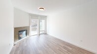 Located at 320 Second Ave S in Kirkland, WA, this one-bedroom, one-bathroom residence offers a well-designed single-floor layout that maximizes every square foot of its compact footprint. The open-concept kitchen and living area serves as the heart of the home, where light hardwood-style flooring flows seamlessly throughout. The kitchen is appointed with gray shaker-style cabinetry, dark granite countertops, a subway tile backsplash, stainless steel appliances including a gas range and microwave, and a peninsula with pendant lighting overhead — ideal for both cooking and casual dining. The living room is anchored by a tile-surround fireplace and benefits from natural light streaming through glass doors that open to an outdoor area. The bedroom is a serene retreat featuring plush carpeting, a ceiling fan, a natural light-filled window, and convenient built-in shelving. The bathroom includes a soaking tub and shower combination with neutral tile surround and wood-look flooring. Additional features include hallway access to a dedicated closet and in-unit laundry. Clean white walls and consistent finishes throughout create a bright, cohesive ambiance.