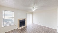 Located at 2176 Cranford Dr in Garland, TX, this two-story home offers 2 bedrooms and 2 bathrooms thoughtfully distributed across two floors. The main level sets a welcoming tone with light wood-look flooring throughout the living and kitchen areas. The living room is a bright, open space anchored by a tile-surround fireplace, a ceiling fan with light fixture, and a sliding glass door that invites natural light. Adjacent to the entry, the kitchen features white cabinetry, an electric range, a refrigerator, and a peninsula breakfast bar that creates a natural divide between cooking and living spaces. The upper floor is home to both bedrooms, each finished with plush carpet and ceiling fans. The primary bedroom is generously proportioned, offering a closet and multiple windows that bring in ample natural light, including a distinctive octagonal window. The second bedroom is equally comfortable with its own closet access and ceiling fan. Both bathrooms are finished in clean, neutral tones, with one featuring a full shower/tub combo with white tile surround and white cabinetry. Throughout the home, textured ceilings, crisp white walls, and consistent flooring selections lend a cohesive, well-maintained aesthetic.