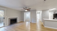Located at 4659 Dawson Blvd in Atlanta, Georgia, this single-floor residence offers a well-designed layout with modern finishes throughout. The open living area is a standout feature, showcasing light hardwood-style flooring, neutral gray walls, a textured ceiling, and a ceiling fan with integrated lighting. A sleek fireplace with a clean white surround serves as a focal point, while sliding glass doors lead to a private outdoor deck overlooking lush, tree-lined surroundings, filling the space with natural light. The kitchen is thoughtfully appointed with gray cabinetry, a white countertop peninsula with an undermount sink, a subway tile backsplash, and a full suite of stainless steel appliances. A hallway connects the living areas to the bedrooms, which feature plush carpet flooring and multiple windows that allow generous amounts of natural light. The bathroom continues the cohesive design with gray vanity cabinetry, a white countertop, a large mirror with contemporary vanity lighting, and a glass-enclosed shower. The entryway, finished with matching hardwood-style floors, provides a clean and welcoming transition into the home. Throughout, the consistent use of soft gray tones and clean white trim creates a modern, cohesive aesthetic.