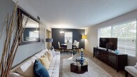 Located on Nob Hill Lane in Louisville, Kentucky, this single-floor residence presents a thoughtfully designed interior with a cohesive, modern aesthetic throughout. The entryway opens into a welcoming living area finished with neutral-toned carpet, a large framed mirror, and abundant natural light filtering through slatted blinds. A tufted white sofa, glass-top coffee table, and warm accent lighting create an inviting atmosphere that flows seamlessly into the adjacent dining area, distinguished by a bold navy accent wall and a contemporary pendant light above a dark-stained dining set.

The kitchen features hardwood-style flooring, rich espresso cabinetry, granite-style countertops, and a full suite of stainless steel appliances, including a refrigerator, dishwasher, range, and microwave. The space is compact yet efficiently arranged for everyday use.

The bedrooms each carry a distinct character through the use of bold accent walls—one in warm gold, another in a striking orange—paired with plush carpeting and natural light from window treatments. Each room provides ample space for furnishings and storage. The bathroom includes a wide vanity with a granite-style countertop, a large framed mirror, and clean, neutral finishes throughout.