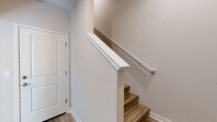 Located in Mountain House, CA, this three-story home offers a clean, modern design with functional living spaces spread across each level. The ground floor houses an attached garage with a spacious concrete floor, automatic opener, and ample room for vehicles and storage. The main living level features an open-concept kitchen and living area highlighted by light hardwood-style flooring, recessed lighting, and a well-appointed kitchen with white shaker cabinetry, dark countertops, a subway tile backsplash, stainless steel appliances including a French door refrigerator, and a central island. The living area includes a dedicated media niche with built-in outlets. The upper floors host four bedrooms, each with ceiling fans and either plush carpet or hardwood-style flooring. Bedrooms feature generous closet space with sliding panel doors and windows that invite natural light and neighborhood views. The four bathrooms are finished consistently with wood-look flooring, white cabinetry, dark countertops, and brushed nickel fixtures — some featuring tub-shower combinations with white tile surrounds. Neutral tones, clean lines, and recessed lighting throughout give the home a cohesive, contemporary feel.