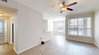 Located at 4807 Pin Oak Park in Houston, TX, this single-story, 2-bedroom, 2-bathroom home offers a thoughtfully designed layout with a clean, neutral aesthetic throughout. The open-concept living and dining area is bright and welcoming, featuring light wood-style laminate flooring, crown molding, a ceiling fan, and multiple windows that allow natural light to fill the space. The kitchen is well-appointed with white cabinetry, stone countertops, a peninsula with a sink, and stainless steel appliances including a range and refrigerator. A pass-through design connects the kitchen seamlessly to the living area, enhancing the open feel. Both bedrooms are generously sized, finished with plush carpet, crown molding, ceiling fans, and windows with views to the outdoors. The primary bedroom benefits from a spacious walk-in closet outfitted with wire shelving and ample storage capacity. The bathrooms are finished with light wood-style tile flooring, white vanities with stone countertops, and a tiled tub-shower combination. A hallway connects the private areas of the home, completing a functional and comfortable floor plan suited for everyday living.