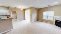 Located at 21 Stockton Ridge in Cranberry Township, PA, this two-bedroom, two-bathroom residence offers a comfortable and functional single-floor layout with a warm, neutral aesthetic throughout. The open living area is a standout, featuring plush carpeting, a corner fireplace, and a large window that invites natural light. Sliding glass doors with vertical blinds lead to an outdoor area, further brightening the space. The combined kitchen and living room area is thoughtfully designed, with the kitchen showcasing white cabinetry, white appliances, recessed lighting, and a peninsula with a sink that overlooks the main living space — ideal for both cooking and entertaining. The primary bedroom is generously sized, featuring a ceiling fan, a large window, and access to a walk-in closet outfitted with extensive wire shelving and hanging rods for organized storage. The second bedroom also offers carpeted flooring and a ceiling fan. Both bathrooms are clean and functional, with one featuring a full soaking tub and shower combination. A dedicated in-unit laundry area adds everyday convenience. A hallway connects the rooms efficiently, completing this well-organized and comfortable Cranberry Township residence.