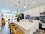 Located at 704 W Tremont Ave in Charlotte's vibrant South End area, this one-bedroom, one-bathroom residence offers a thoughtfully designed open-concept layout finished with contemporary details throughout. Wood-look flooring flows seamlessly from room to room, creating a cohesive and warm aesthetic.

The kitchen is a standout feature, showcasing crisp white shaker cabinetry with matte black hardware, a bold blue subway tile backsplash, quartz countertops, and stainless steel appliances. A generously sized island with pendant lighting overhead provides both additional prep space and seating for casual dining.

The living area is bright and inviting, benefiting from large windows that allow abundant natural light to fill the space. A ceiling fan adds comfort and functionality to the room.

The bedroom is a comfortable retreat, featuring a walk-in closet with built-in shelving and large windows that continue the home's commitment to natural light. A ceiling fan completes the room.

The bathroom is finished with a white vanity, quartz countertop, matte black hardware, and a soaking tub and shower combination framed by striking dark slate-style tile. The overall design is clean, modern, and cohesive, making this residence a polished and functional home in the heart of Charlotte.